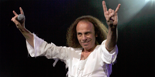 Ronnie James Dio in concert flashing devil horns.